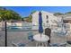 Community pool with patio table and lounge chairs on a sunny day at 500 New York Ave # 23, Dunedin, FL 34698