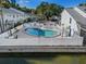 Community pool with crystal clear water, surrounded by lounge chairs and a white picket fence near the water at 500 New York Ave # 23, Dunedin, FL 34698