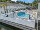 Beautiful community pool area surrounded by white fencing and lounge chairs at 500 New York Ave # 23, Dunedin, FL 34698