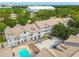 Aerial view of condo complex near green spaces and amenities with a pool and parking at 5052 Sunridge Palms Dr # 102, Tampa, FL 33617