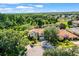 A home with manicured landscaping, mature trees, and a serene pond, creating a picturesque setting at 5160 Loquat Ct, Palm Harbor, FL 34685