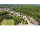 Aerial shot of a residential area showcasing well-maintained homes, mature trees, and a serene pond at 5160 Loquat Ct, Palm Harbor, FL 34685