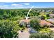 A home with manicured landscaping, mature trees, and a serene pond, creating a picturesque setting at 5160 Loquat Ct, Palm Harbor, FL 34685