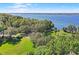 Scenic aerial view of a lakefront property featuring lush greenery, a park, and the tranquil waters of the lake at 5160 Loquat Ct, Palm Harbor, FL 34685
