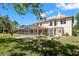 Expansive backyard featuring a screened pool enclosure, landscaping, and a spacious grassy area at 5160 Loquat Ct, Palm Harbor, FL 34685