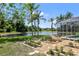 A tranquil backyard with a screened lanai, well-manicured garden, and picturesque pond view at 5160 Loquat Ct, Palm Harbor, FL 34685