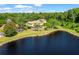 Aerial view showcasing the house with large backyard, beautiful pond and surrounding green scenery at 5160 Loquat Ct, Palm Harbor, FL 34685