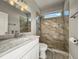 Modern bathroom features a marble tiled shower with glass enclosure, granite counters, and a window for natural light at 5160 Loquat Ct, Palm Harbor, FL 34685