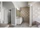 Bathroom with marble column, vanity, decorative mirror, tiled walls, and open entry at 5160 Loquat Ct, Palm Harbor, FL 34685