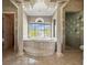 Luxurious primary bathroom featuring columns, tile flooring, a large soaking tub, and a separate glass shower at 5160 Loquat Ct, Palm Harbor, FL 34685