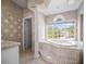Bathroom with large tub, beautiful tiles, and natural light at 5160 Loquat Ct, Palm Harbor, FL 34685
