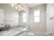 Modern bathroom featuring a soaking tub, white tiling, and a granite sink at 5160 Loquat Ct, Palm Harbor, FL 34685