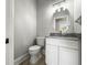 Cozy powder room with modern fixtures, a marble countertop, and a stylish mirror at 5160 Loquat Ct, Palm Harbor, FL 34685