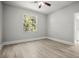 Empty bedroom with modern flooring, neutral walls, a ceiling fan, and natural light streaming in from a window at 5160 Loquat Ct, Palm Harbor, FL 34685