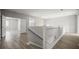 Upstairs hallway with a gray color scheme, wooden floors, and views to multiple rooms at 5160 Loquat Ct, Palm Harbor, FL 34685