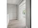 Hallway featuring wooden floors, gray walls, and white trim details leading to an open room at 5160 Loquat Ct, Palm Harbor, FL 34685