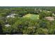 Aerial view of a green sports field surrounded by lush trees and some buildings in the distance at 5160 Loquat Ct, Palm Harbor, FL 34685