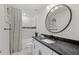 Stylish bathroom featuring a modern shower curtain and a round mirror at 5634 Clearwater Ct, Lakewood Ranch, FL 34211