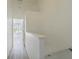 Well-lit hallway featuring white walls and leading to the bedroom with light tile flooring at 6229 Bayside Key Dr, Tampa, FL 33615