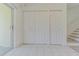 Hallway with white tile floor and multiple storage closets, stairs nearby at 6229 Bayside Key Dr, Tampa, FL 33615