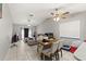 Bright and open-concept living and dining area with tile flooring, ceiling fans, and ample natural light at 7124 Barclay Ave # A, Spring Hill, FL 34609