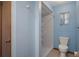 Bathroom with a toilet, walk-in shower, small window, and blue walls at 8332 Berkeley Manor Blvd, Spring Hill, FL 34606