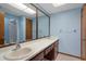 A large bathroom featuring double sinks, a big mirror, and wood cabinets at 8332 Berkeley Manor Blvd, Spring Hill, FL 34606