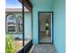 View from the screened porch into the home's entry, showing tile flooring and a blue door at 8332 Berkeley Manor Blvd, Spring Hill, FL 34606