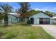Inviting single-story home features a neatly kept lawn, mature trees and a two-car garage at 8332 Berkeley Manor Blvd, Spring Hill, FL 34606