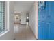 Bright foyer with tiled flooring, a blue front door and a view into the living spaces at 8332 Berkeley Manor Blvd, Spring Hill, FL 34606