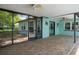 View of an enclosed patio with brick flooring, a light blue house exterior, and two ceiling fans above at 8332 Berkeley Manor Blvd, Spring Hill, FL 34606