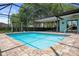 A pristine pool area with a screen enclosure, inviting patio, and a tranquil outdoor living space at 8332 Berkeley Manor Blvd, Spring Hill, FL 34606