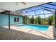 A screened-in pool and patio area featuring brick pavers and a house painted in a light aqua color with white trim at 8332 Berkeley Manor Blvd, Spring Hill, FL 34606