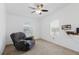 Bedroom with neutral walls and carpet, featuring a ceiling fan, windows, and recliner at 8471 Fantasia Park Way, Riverview, FL 33578