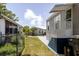 View of manufactured home from yard with well maintained lawn, steps leading up to entrance, and adjacent property views at 8471 Fantasia Park Way, Riverview, FL 33578