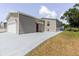A charming home featuring tan siding, a garage, and a red front door with a freshly painted driveway at 8471 Fantasia Park Way, Riverview, FL 33578