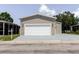 Attached two-car garage featuring a white door with an ample freshly painted driveway at 8471 Fantasia Park Way, Riverview, FL 33578