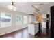 Bright eat-in kitchen with a center island featuring stainless steel sink, white cabinets and dark wood-look flooring at 8471 Fantasia Park Way, Riverview, FL 33578