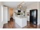 Well-appointed kitchen with white cabinets, island, granite countertops, stainless steel sink, and modern black appliances at 8471 Fantasia Park Way, Riverview, FL 33578