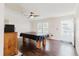 Spacious living area with a covered pool table, dark wood floors and a glass paneled door at 8471 Fantasia Park Way, Riverview, FL 33578