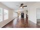 Living room showcasing hardwood floors, a ceiling fan, and an open layout to the kitchen at 8471 Fantasia Park Way, Riverview, FL 33578
