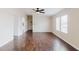 Bright living room featuring wood floors, ceiling fan, and plenty of natural light from the double windows at 8471 Fantasia Park Way, Riverview, FL 33578