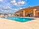 Community swimming pool view showing surrounding lounge chairs, the building and a partly cloudy sky at 8471 Fantasia Park Way, Riverview, FL 33578