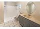 Bathroom with a tile floor, stand-up shower, and vanity with round mirror at 8812 Bayaud Dr, Tampa, FL 33626