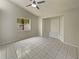 This bright bedroom features neutral paint, tiled floors, a large window and a built-in bench at 8812 Bayaud Dr, Tampa, FL 33626