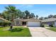 Lovely single-story home boasts a green lawn, a palm tree, and an attached two-car garage at 8812 Bayaud Dr, Tampa, FL 33626