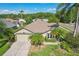 Charming single-story home with well-manicured lawn, mature palm trees, and inviting curb appeal at 892 Crestridge Cir, Tarpon Springs, FL 34688