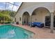 Covered outdoor patio with seating area, perfect for entertaining by the pool at 892 Crestridge Cir, Tarpon Springs, FL 34688