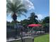 Waterfront view featuring a private dock with a pontoon boat, enhanced by a palm tree and a black metal fence at 10142 118Th Ave, Largo, FL 33773
