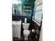 Stylish bathroom with a sink, toilet, and shelves, complemented by unique floral wallpaper and black tiles at 10308 Fore Dr, Tampa, FL 33612